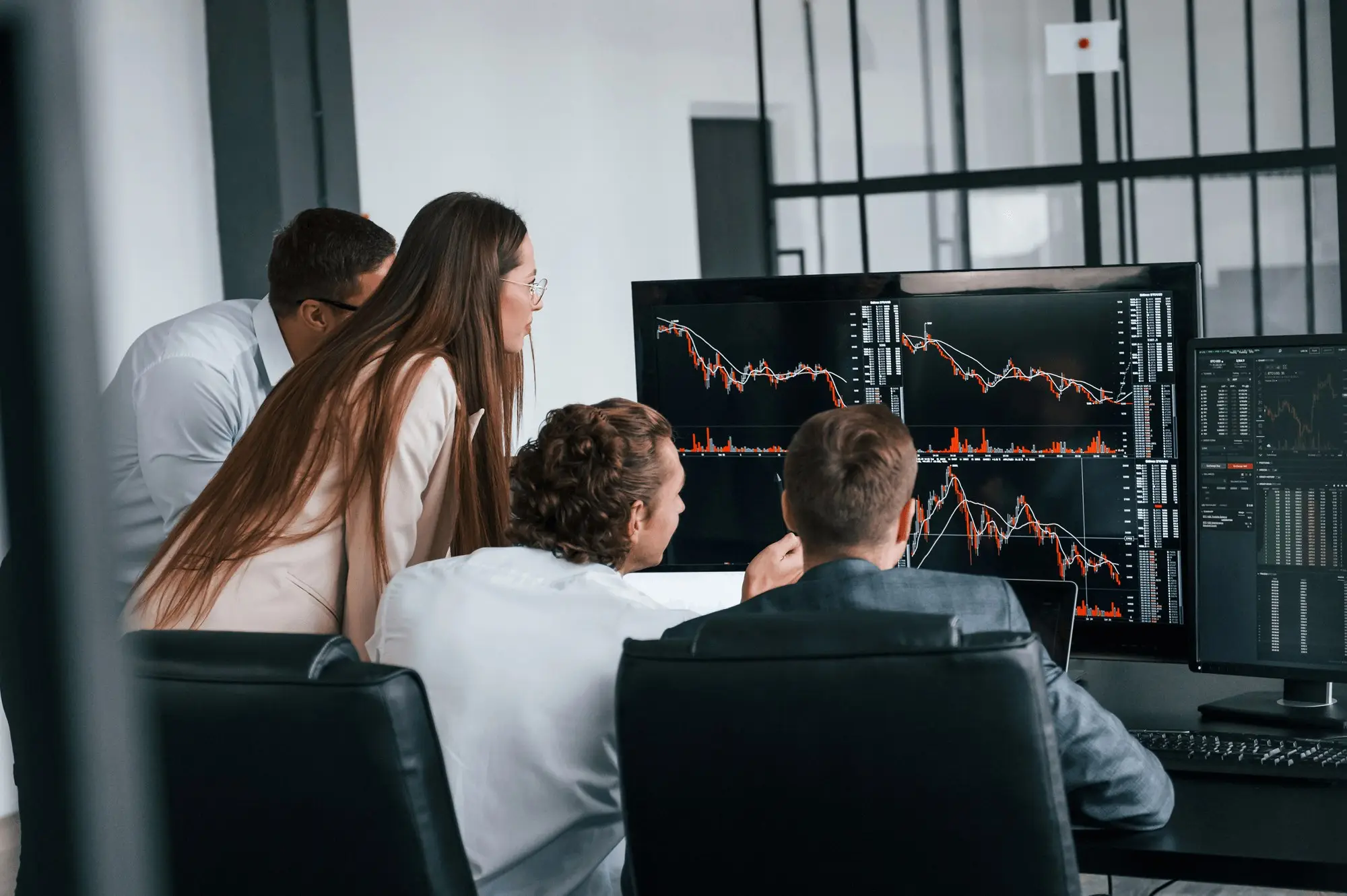 Personen betrachten in einem Meeting Bildschirme mit Statistiken und Diagrammen