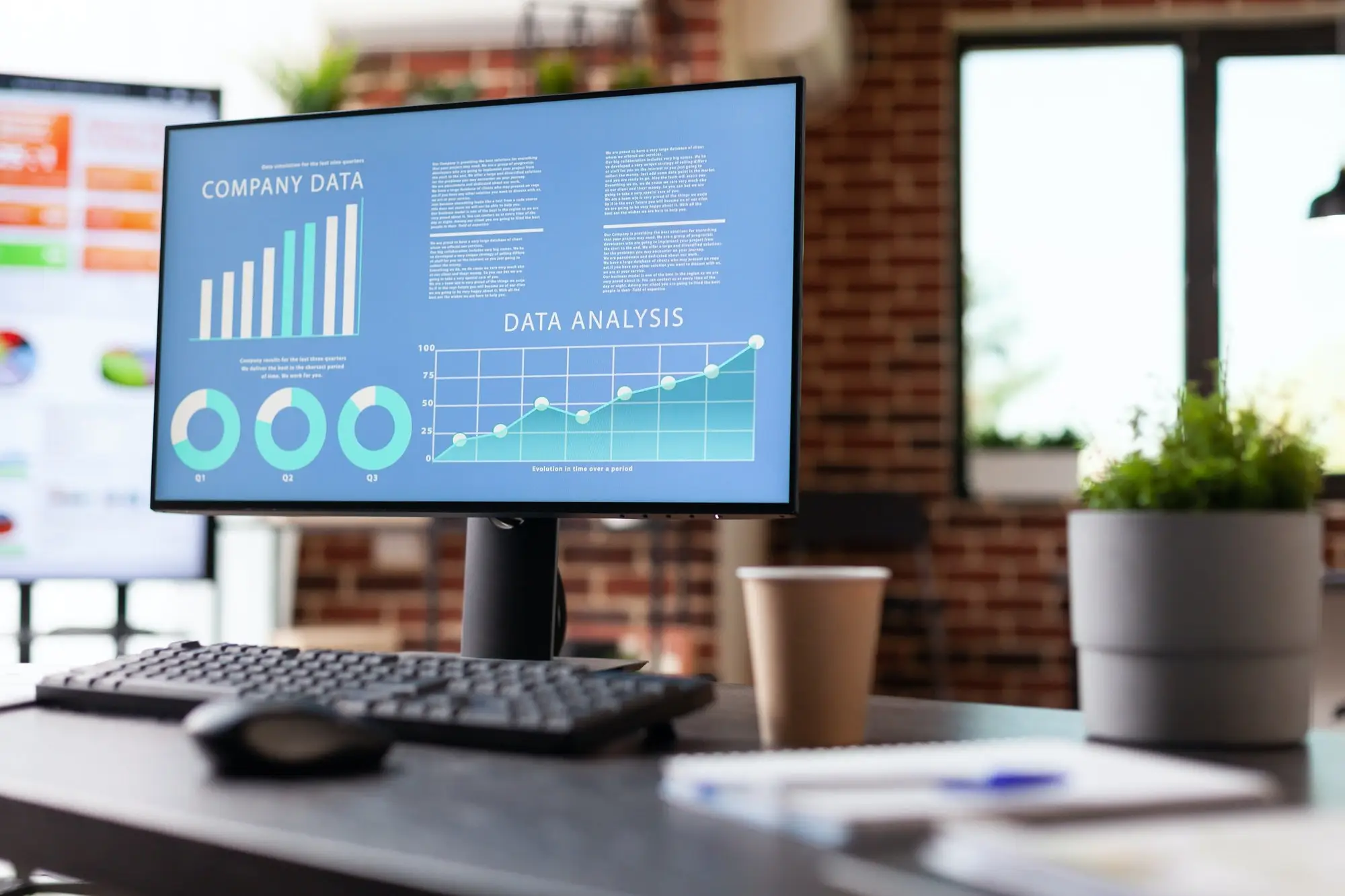 Ein Monitor zeigt ein Analytics-Dashboard mit Diagrammen auf einem Schreibtisch